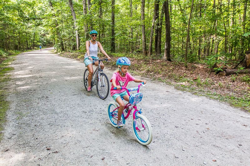 caz and savannah riding bikes on Umstead State Park trail