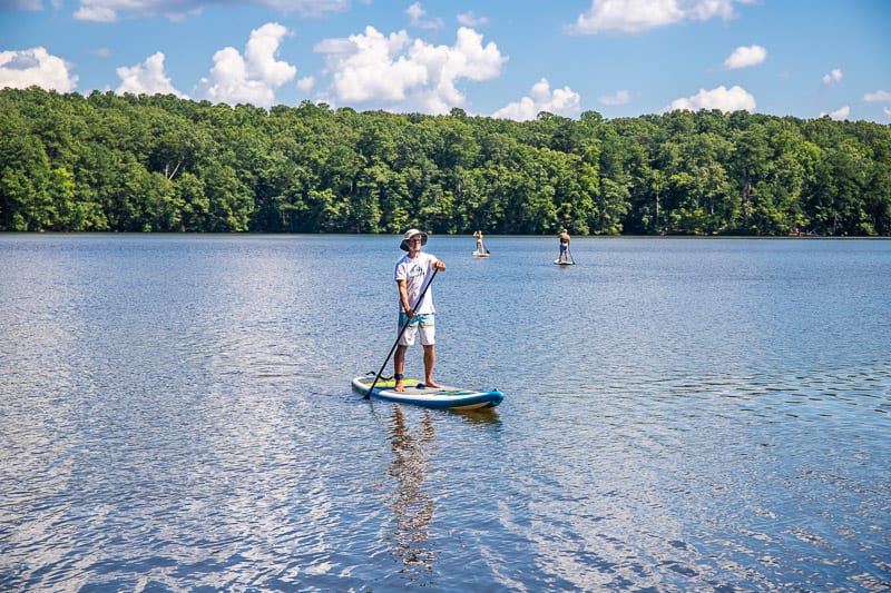 a man stand up paddle boarding on a lake