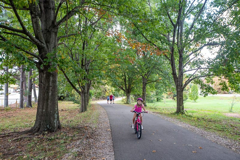 girl riding a bike through a park