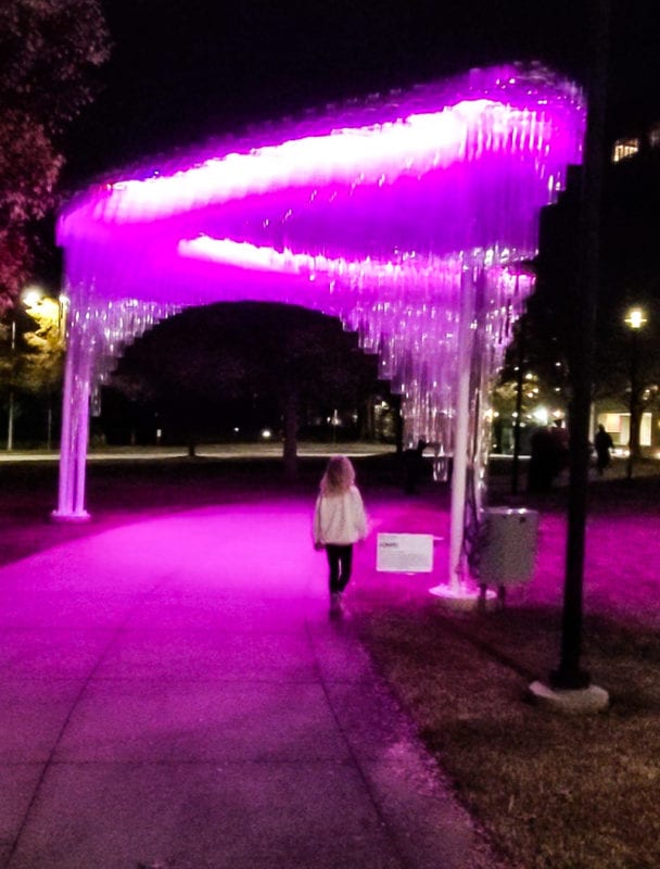 girl walking under purple lights
