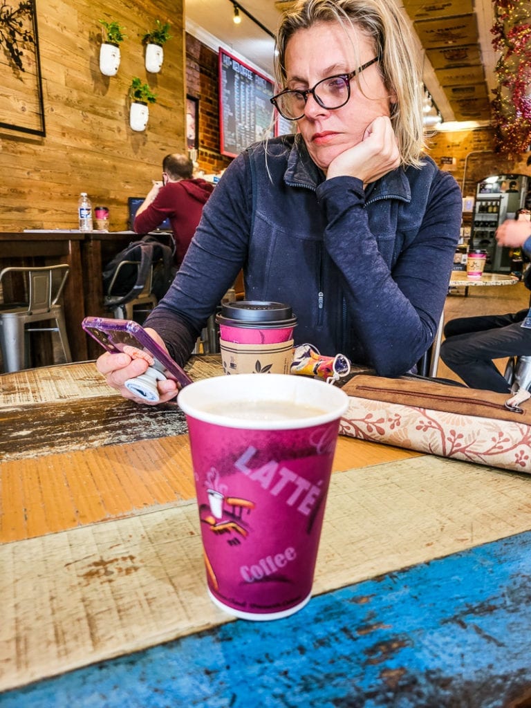 A person sitting at a table with a cup of coffee