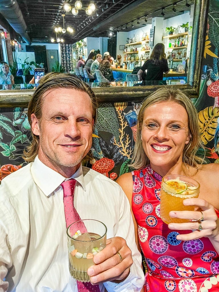 people smiling for the camera while holding drinks