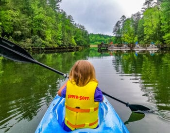 a girl kayaking on a body of water