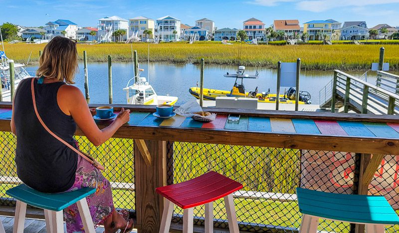 woman sitting at table with coffee looking at waterway views