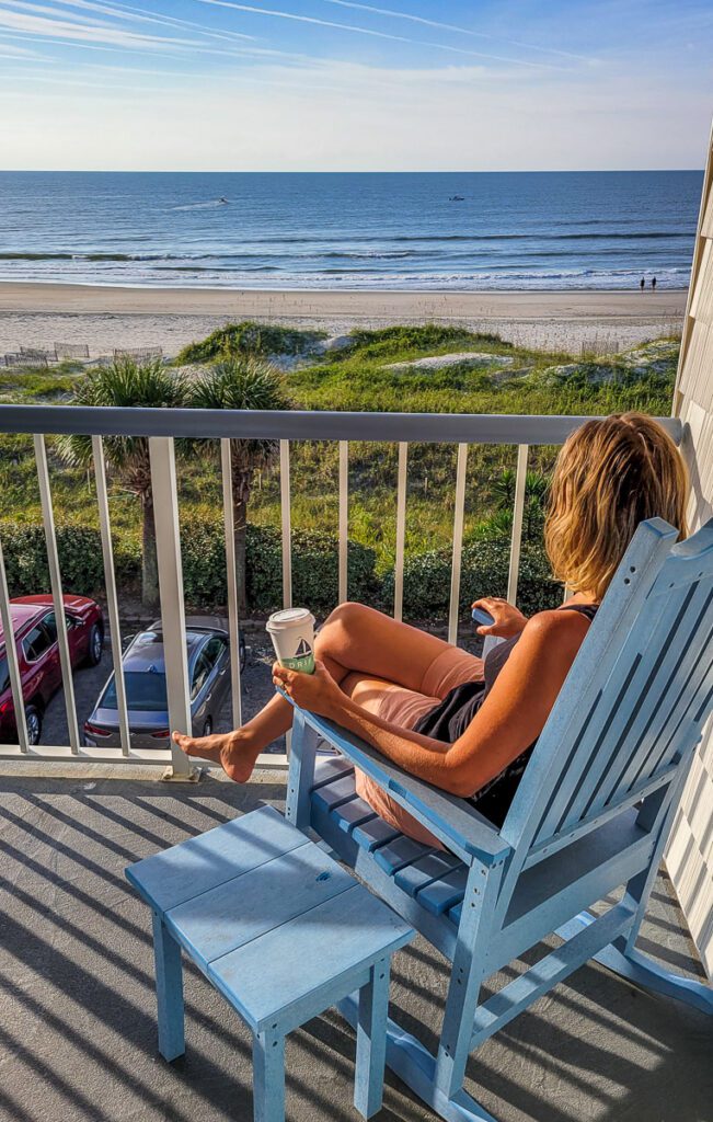 A person sitting on a balcony overlooking the ocean