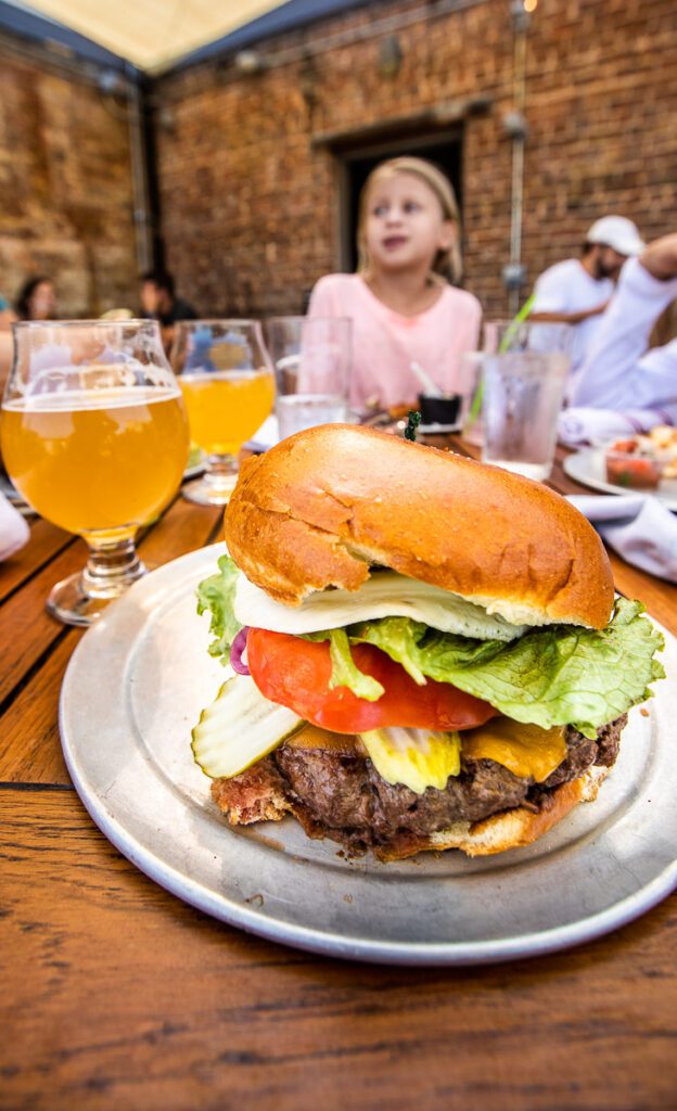 burger on a tray with beers in the background