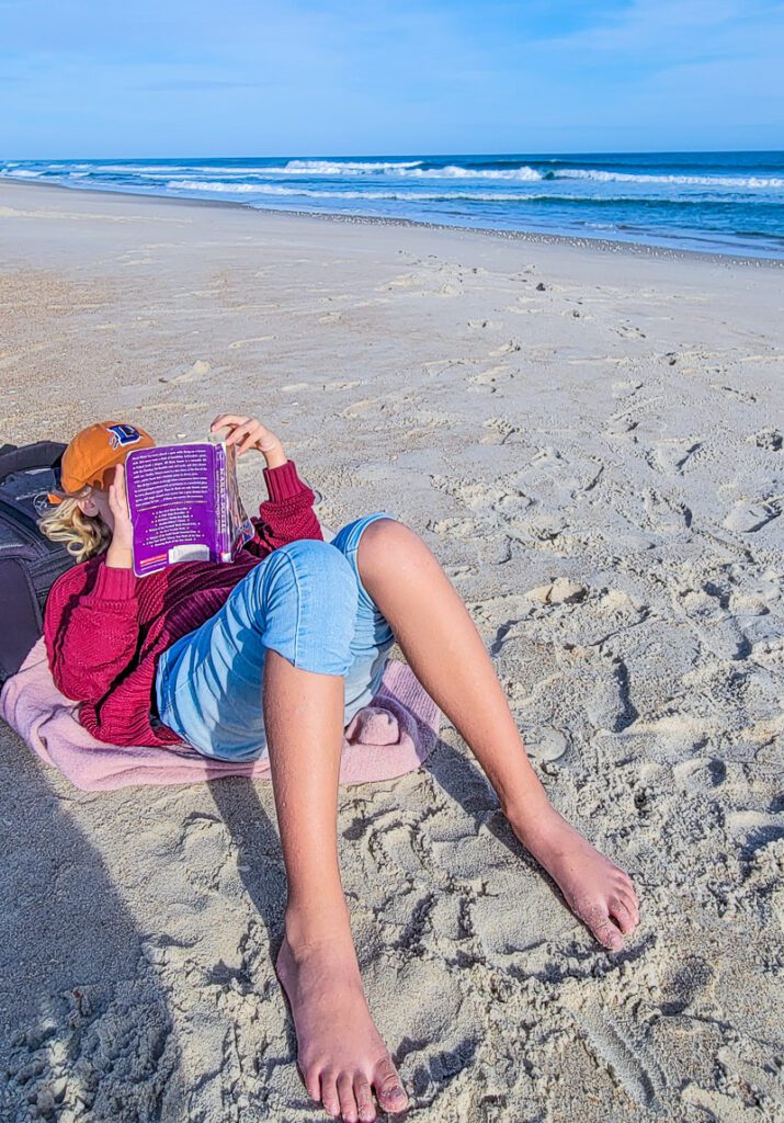 A person sitting on a sandy beach