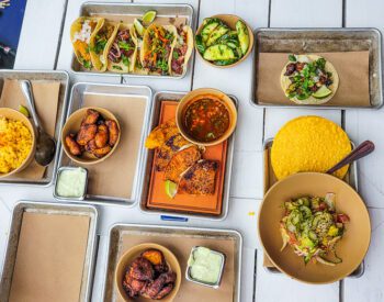 a table filled with different types of mexican food on a plate, cartaco raleigh