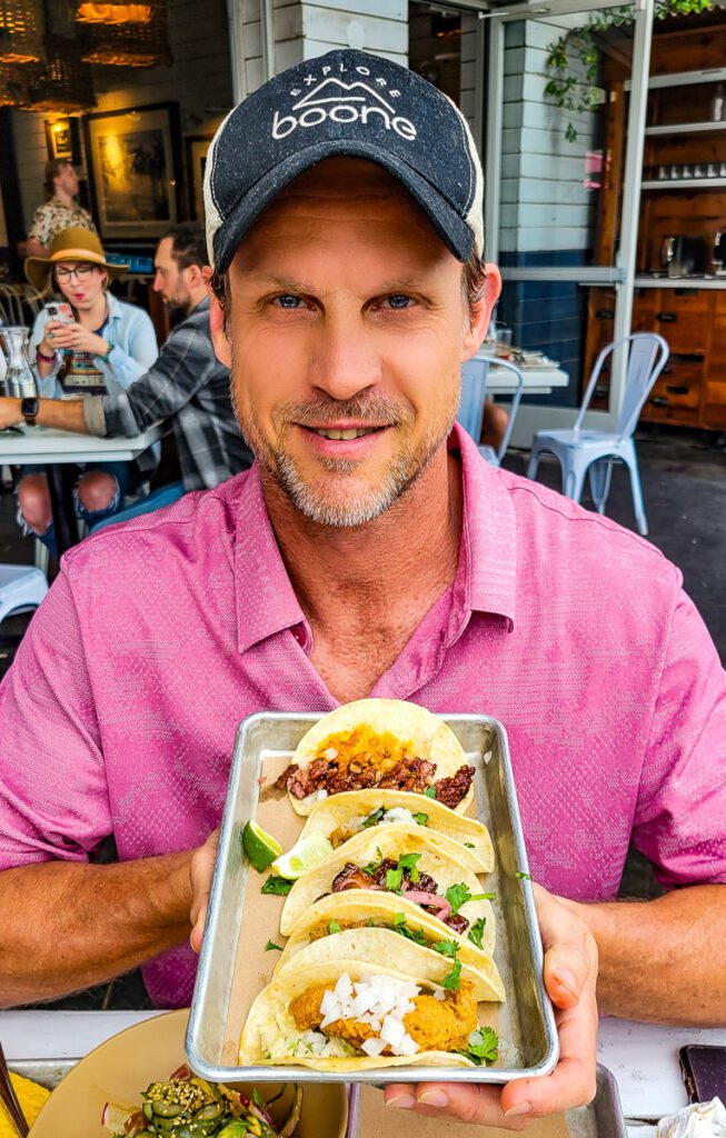 Craig Makepeace sitting at a table with a plate of food, with bartaco