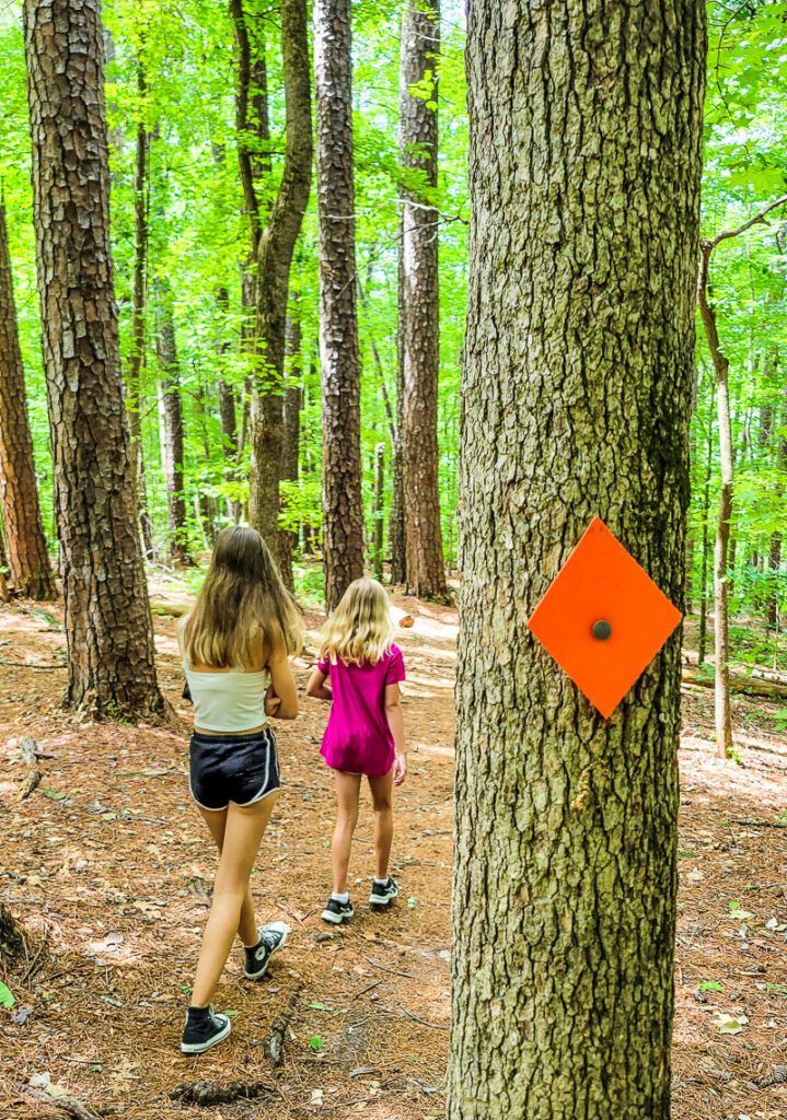 two children standing next to a tree, with Pott\'s Branch Trail