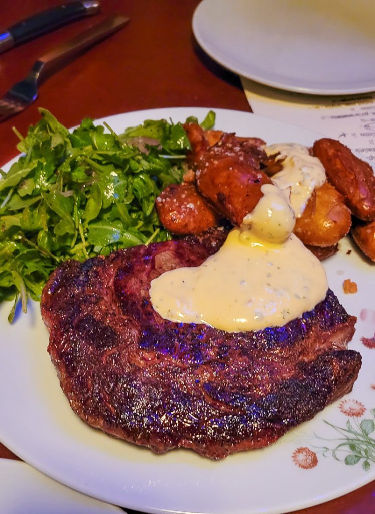 Ribeye steak and arugula on a plate at Stanbury, Raleigh