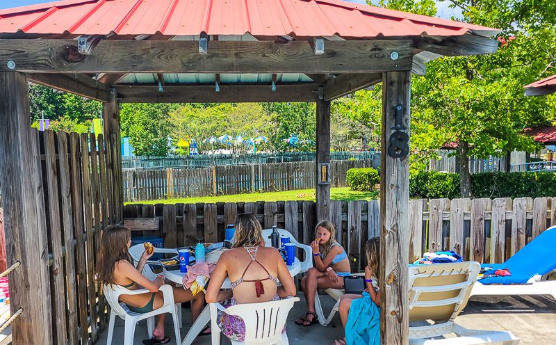 A woman and children sitting under a cabana Wet\'n Wild Greensboro