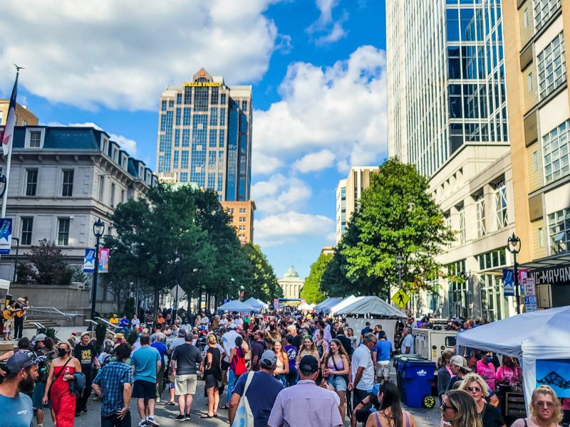 People enjoying an outdoor street festival in Raleigh