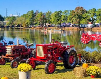 Two red tractors parked by a lake