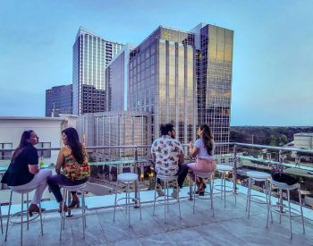 People having drinks at a rooftop bar with city views