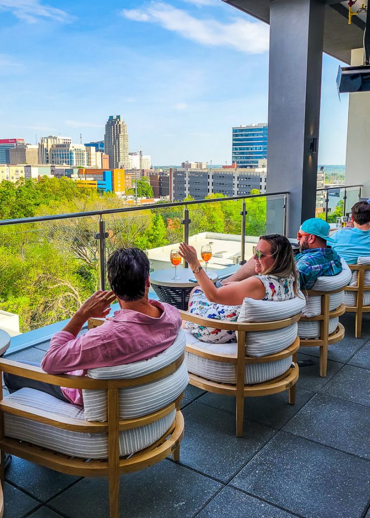 People enjoying drinks on a rofftop bar with city views