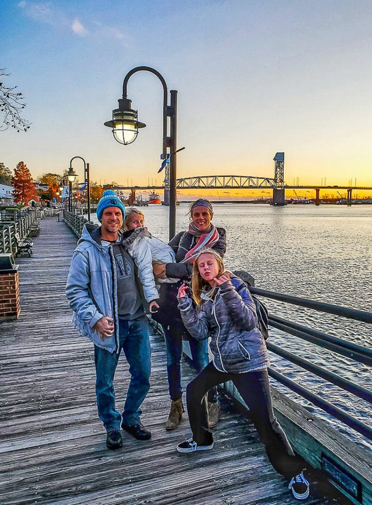 Family posing for a photo on a riverfront
