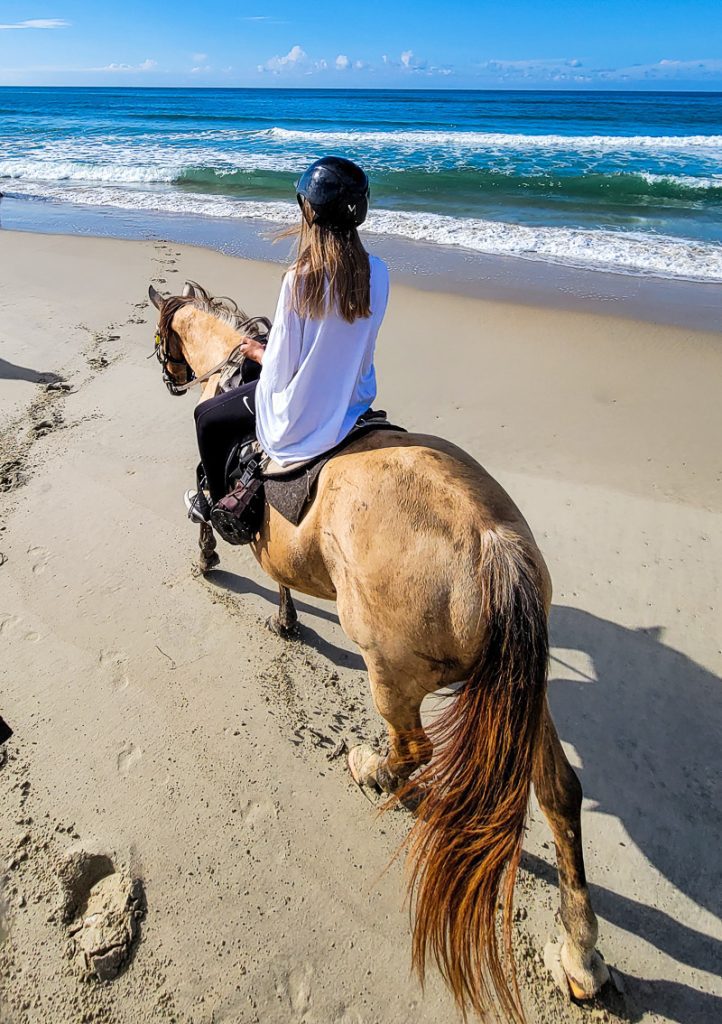 Girl riding a horse on a beach in the Outer Banks
