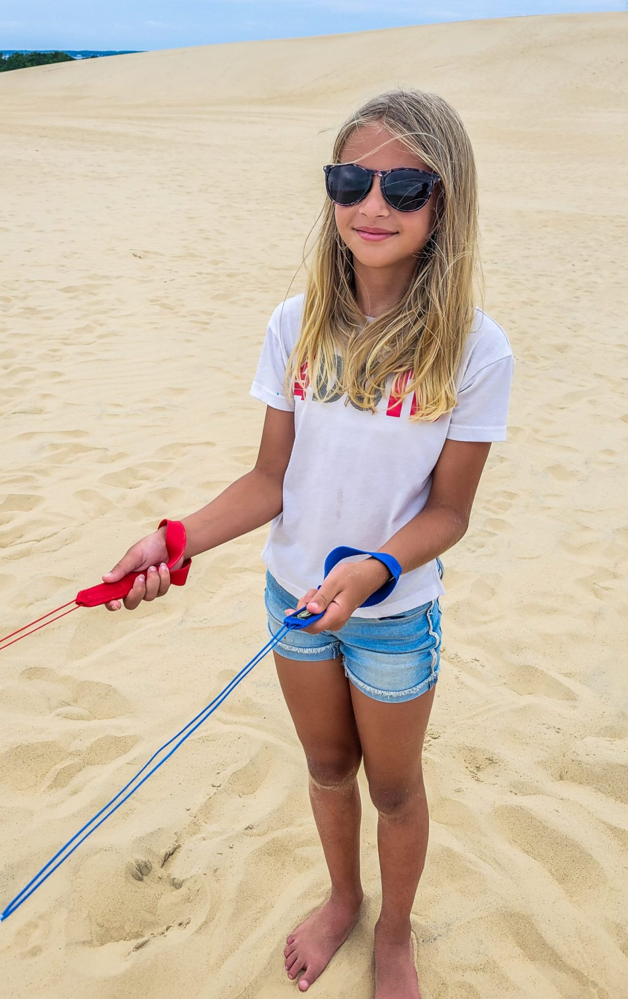 Girl flying a kite in the sand dunes at Outer Banks