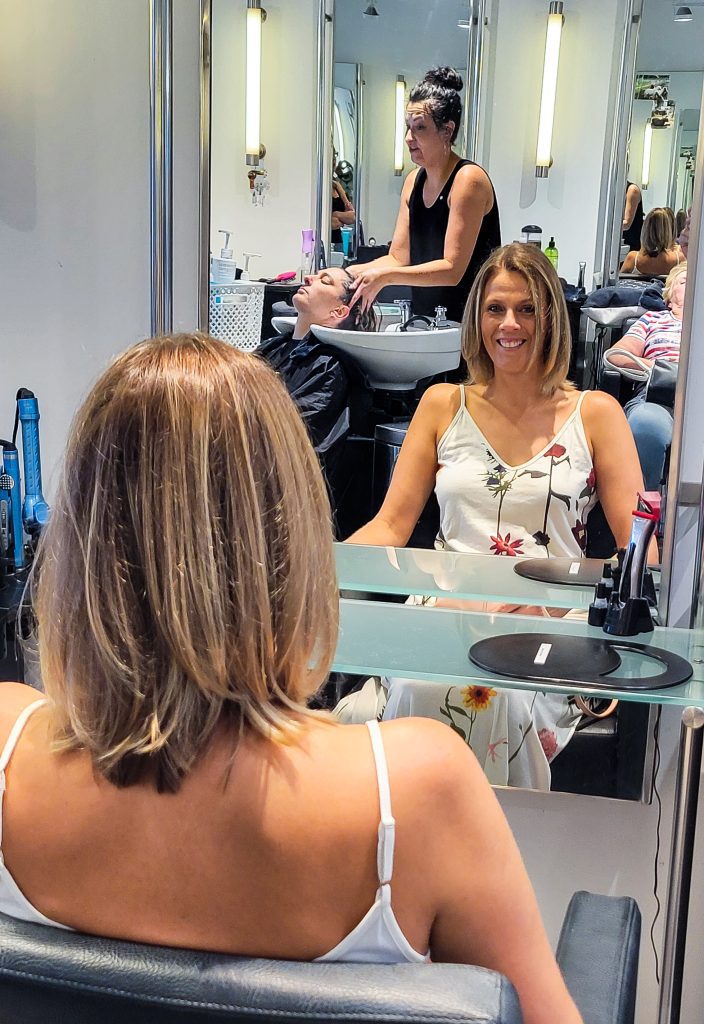 Lady looking in mirror at the hair dressers