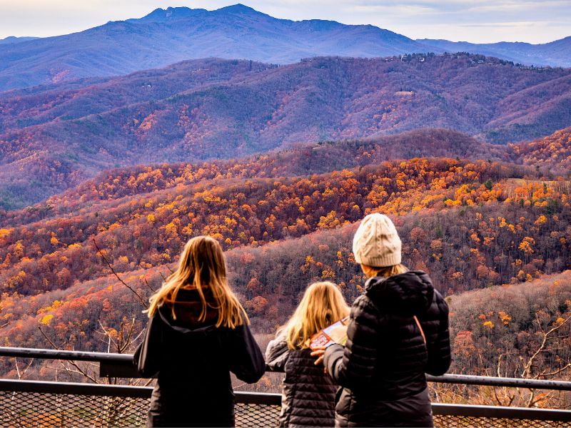 Three women overlooking the mountains during Fall season