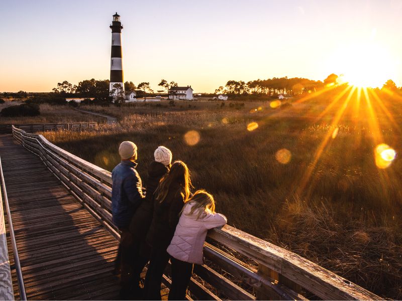 Family watching the sunset at a light house in the Outer Banks