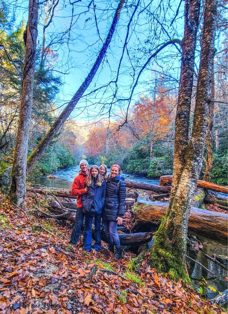 Family posing for a photo on a hiking trail during Fall in the Great Smoky Mountains