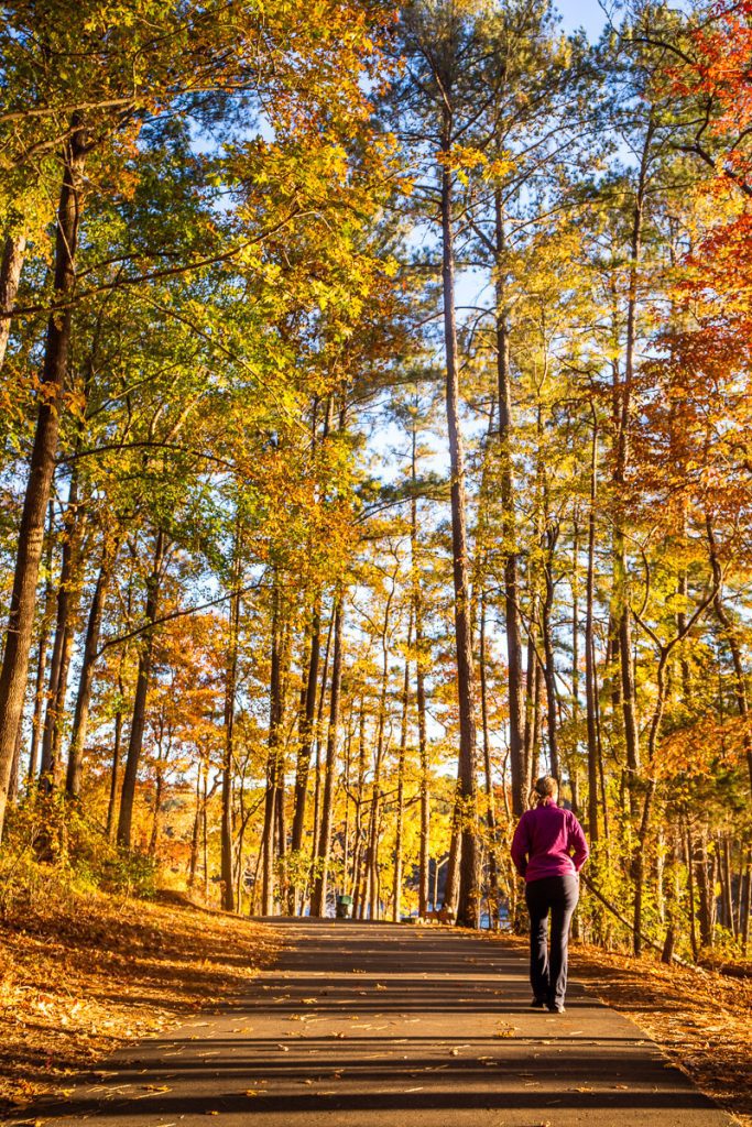woman walking along trail in the fall
