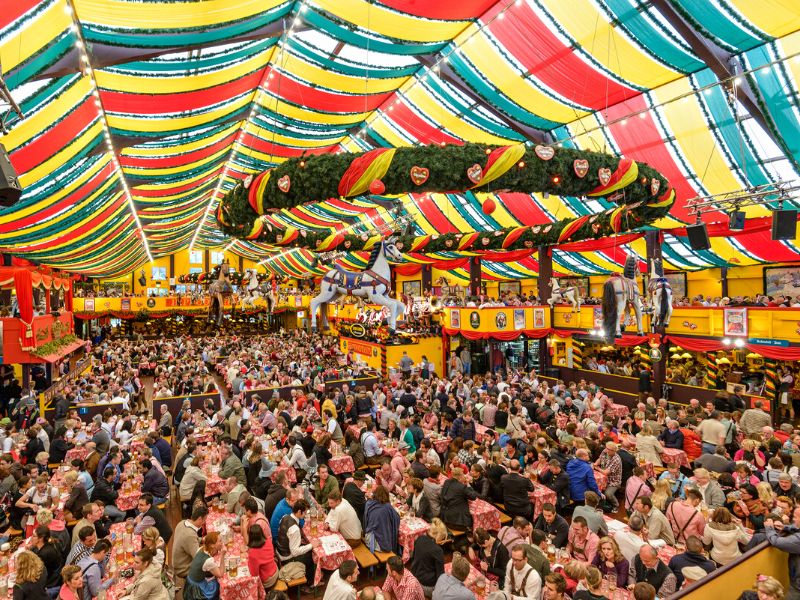 Large group of people celebrating in a tent for Oktoberfest in Munich