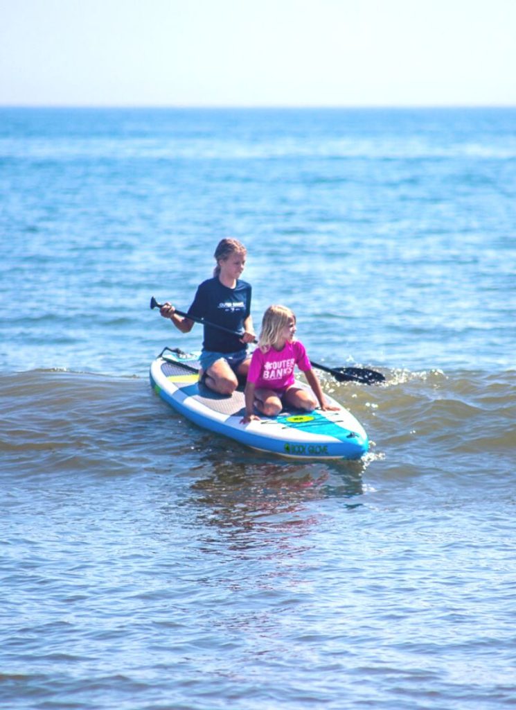 Girls paddle boarding in the ocean at Outer Banks