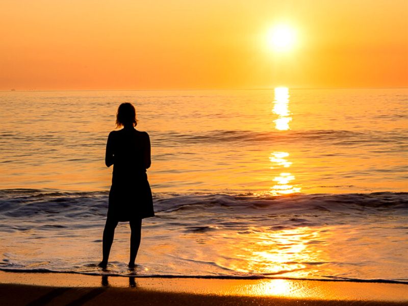 Lady watching the sunrise over the ocean in the Outer Banks