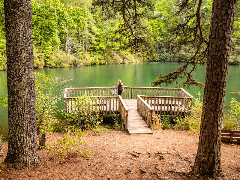 Woman standing on a deck overlooking a lake at Unicoi State Park