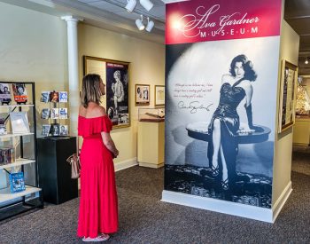 Woman admiring a poster of Ava Gardner in a museum