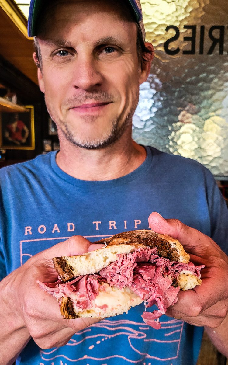 Man holding a reuben sandwich
