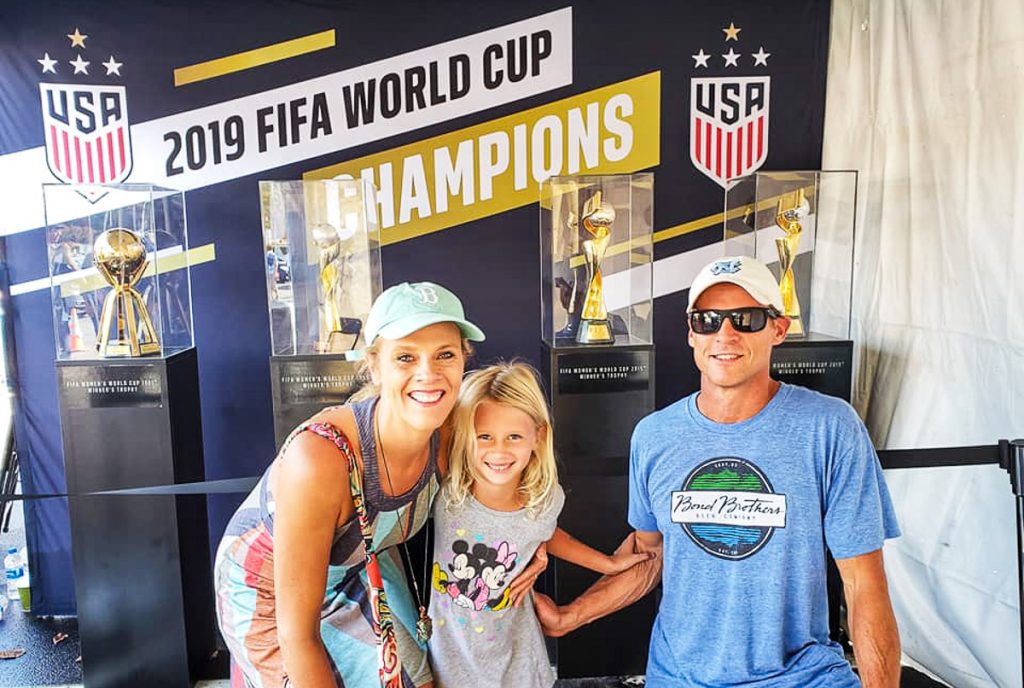 family posing in front of trophies