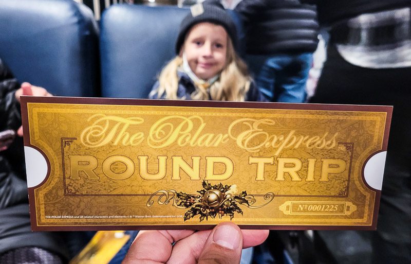Child holding a golden ticket to the Polar Express