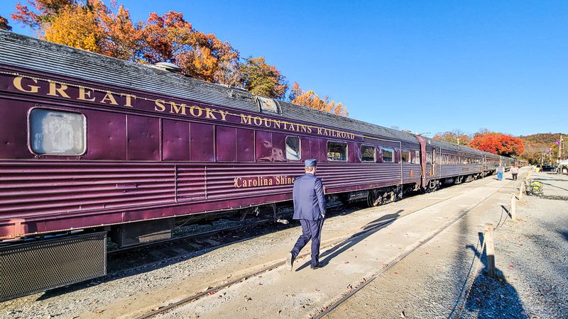 conductor walking beside diesel great smoky  mountains historic train