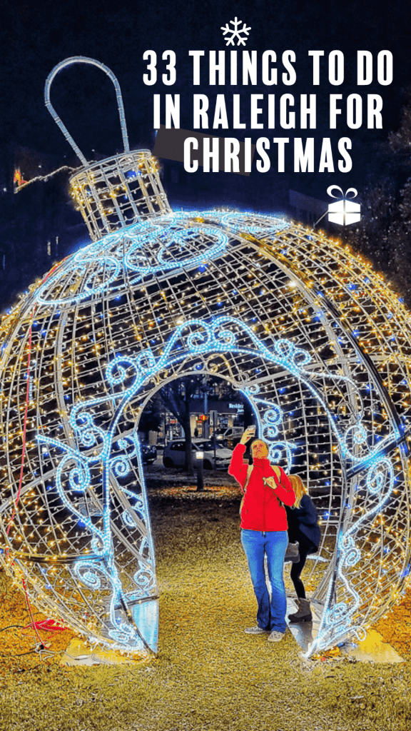 woman standing inside illuminated christmas ball sculpture