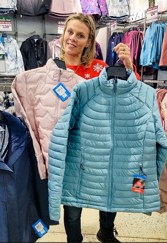 Lady holding up a jacket in a store