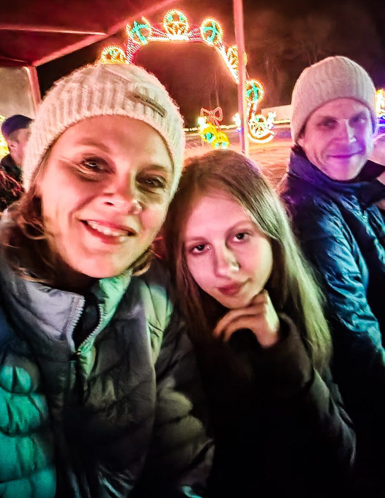 Mom and daughter getting a photo in front of Christmas lights display