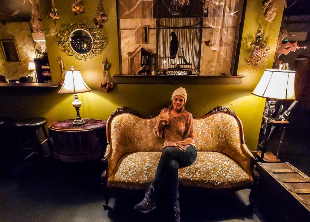 Lady sitting on an antique couch in a speakeasy bar