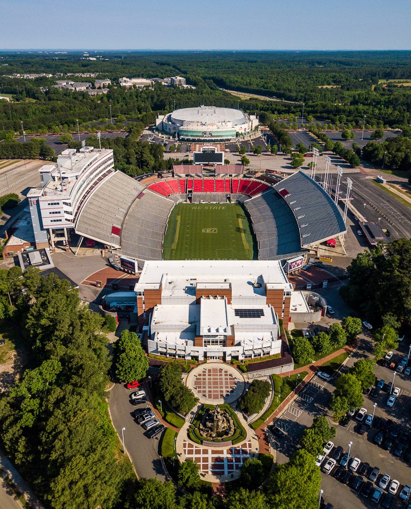 Aerial view of a college football stadium surrounded by trees