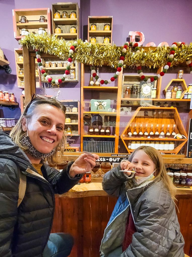 Mom and daughter tasting honey in a store