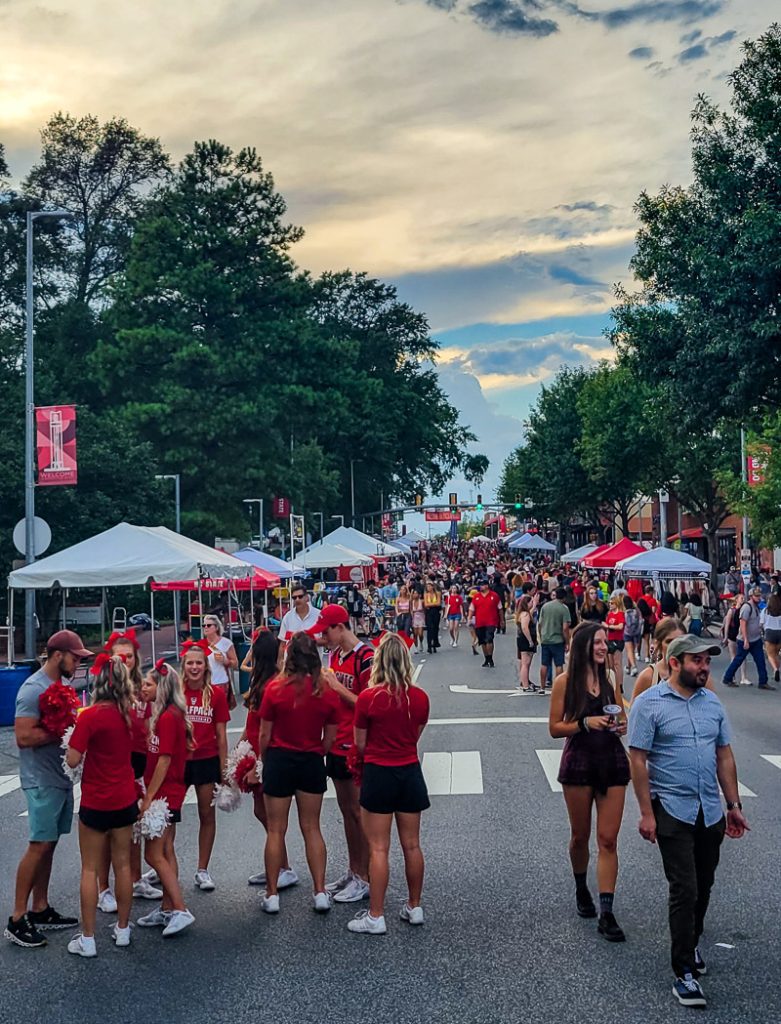University students lining the street on campus at a festival