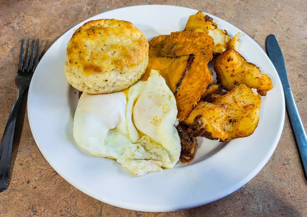 Plate of eggs, potatoes and a biscuit