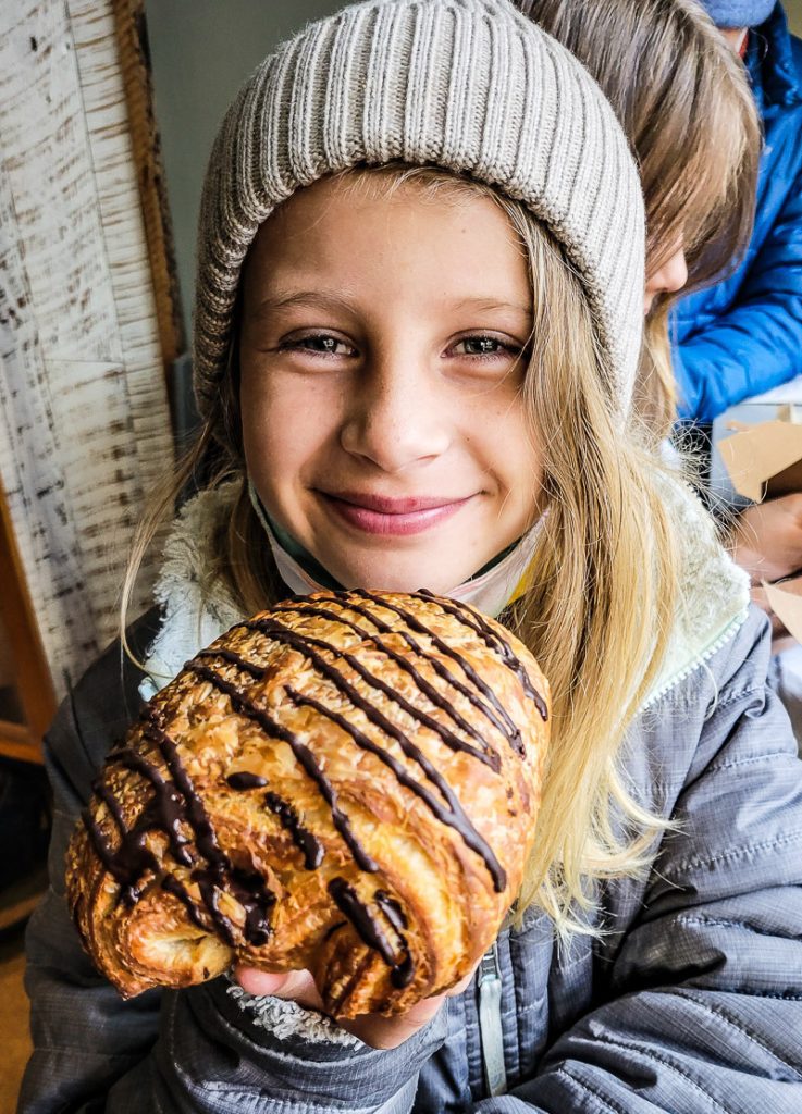 Girl eating a chocolate croissant