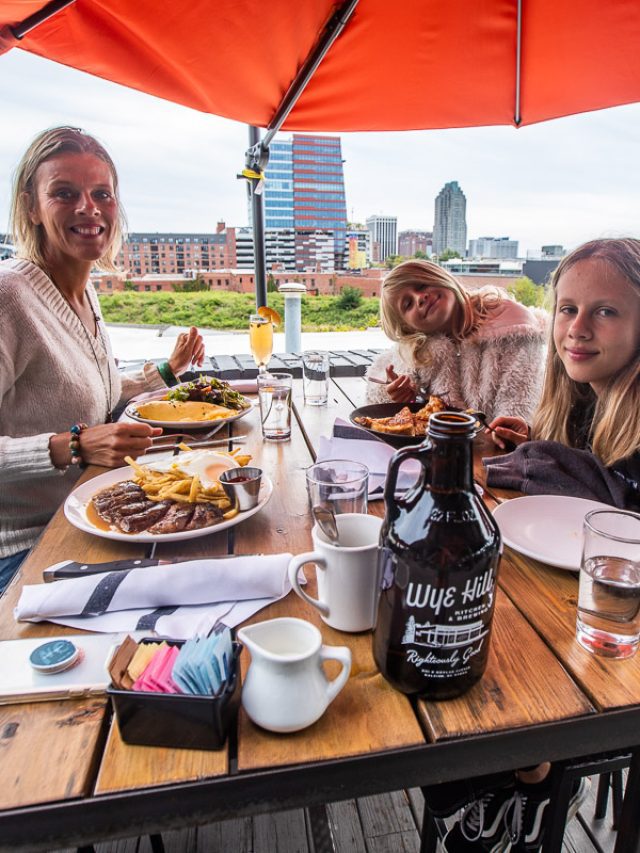 Mon and two daughters eating brunch with a view of the city