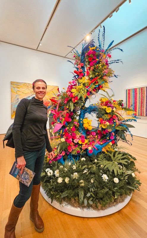woman standing next to floral display arranged into a musical note