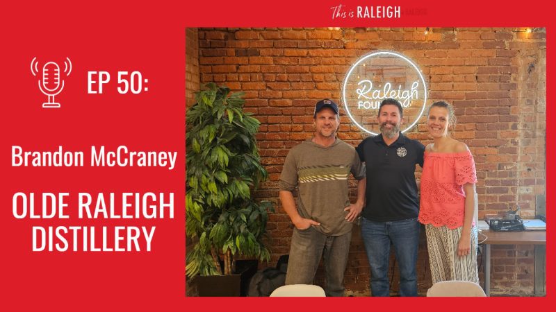 Three people standing for a phot with the words Olde Raleigh Distillery
