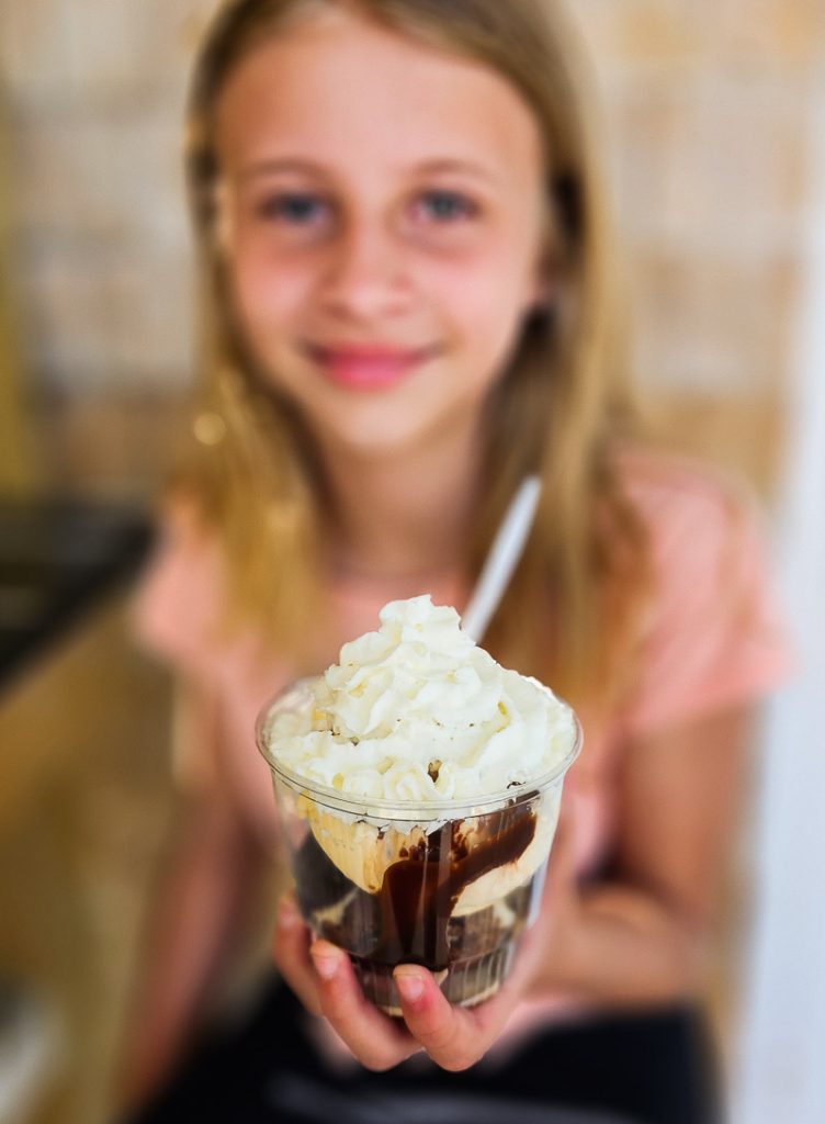 Girl holding up a cup of ice cream